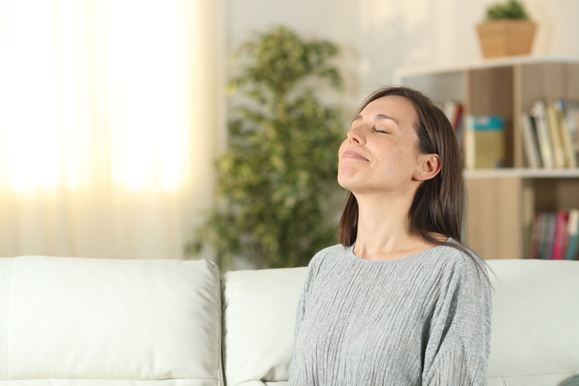 Relaxed woman at home breathing fresh air